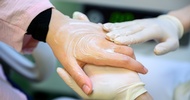 Nahaufnahme der Hand einer Person, die von den Händen einer anderen Person eingecremt wird