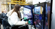  Eine Person sitzt hinter einem Simulator und hält einen Joystick in der Hand