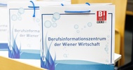 Auf einem Tischen stehen hintereinander drei Papiersackerl. Auf allen steht Berufsinformationszentrum der Wiener Wirtschaft