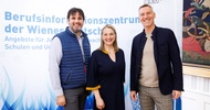Porträt dreier nebeneinander stehender Personen. Hinter ihnen ist ein großer Banner, auf dem Berufsinformationszentrum der Wiener Wirtschaft steht