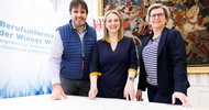 Porträt dreier nebeneinander stehender Personen. Hinter ihnen ist ein großer Banner, auf dem Berufsinformationszentrum der Wiener Wirtschaft steht