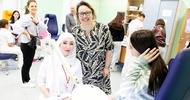 Personen sitzen bei Behandlungstisch und lächeln