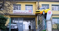 Fassade eines zweistöckigen Hauses mit einer Garageneinfahrt. Über der Einfahrt hängt ein Schild, auf dem Mobilitätscampus steht. Daneben ist ein Werbebanner, auf dem Biwi steht