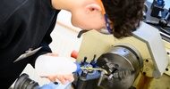  Aufnahme einer Person mit Schutzbrille, die neben einem Gerät steht