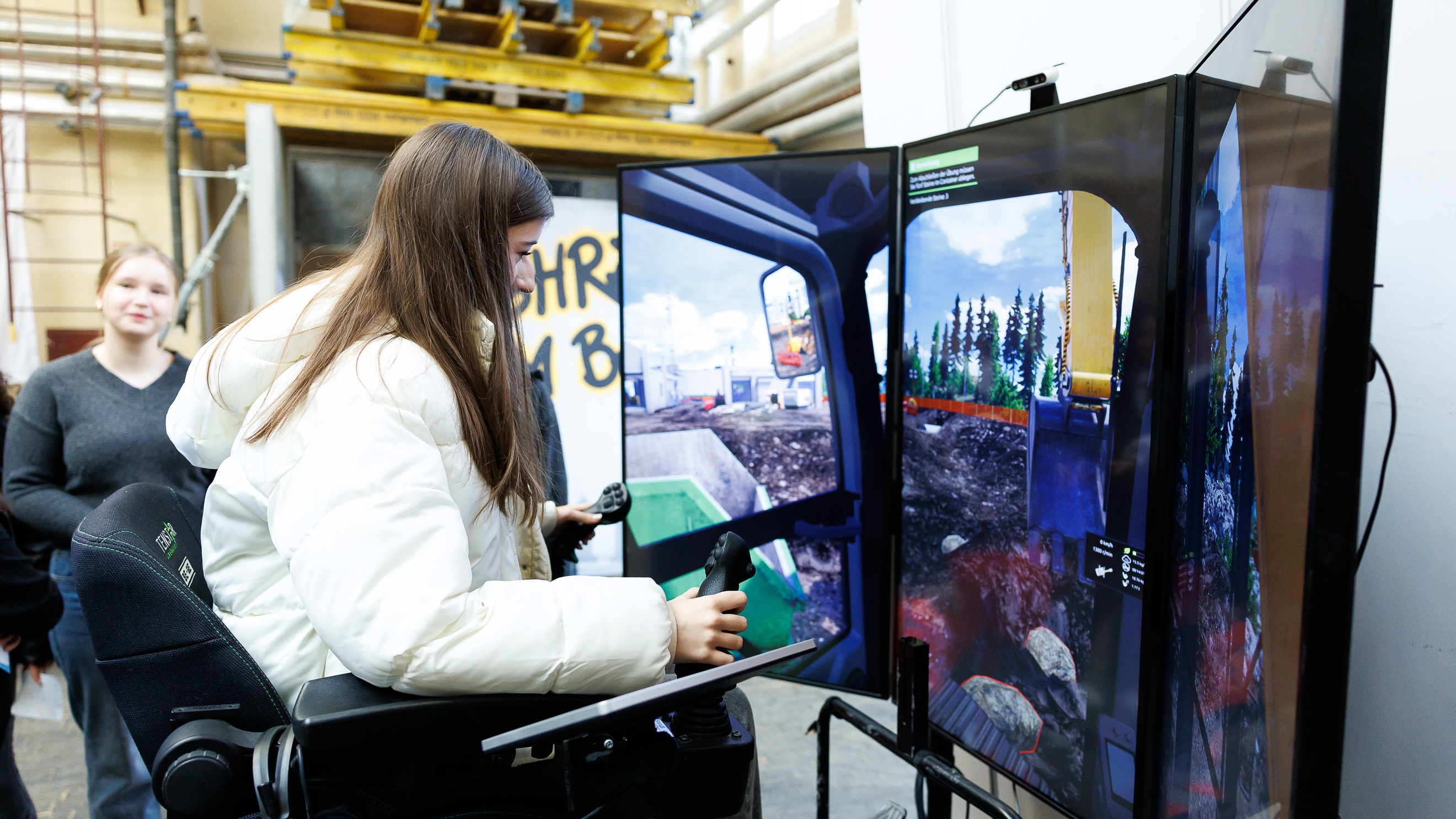  Eine Person sitzt hinter einem Simulator und hält einen Joystick in der Hand