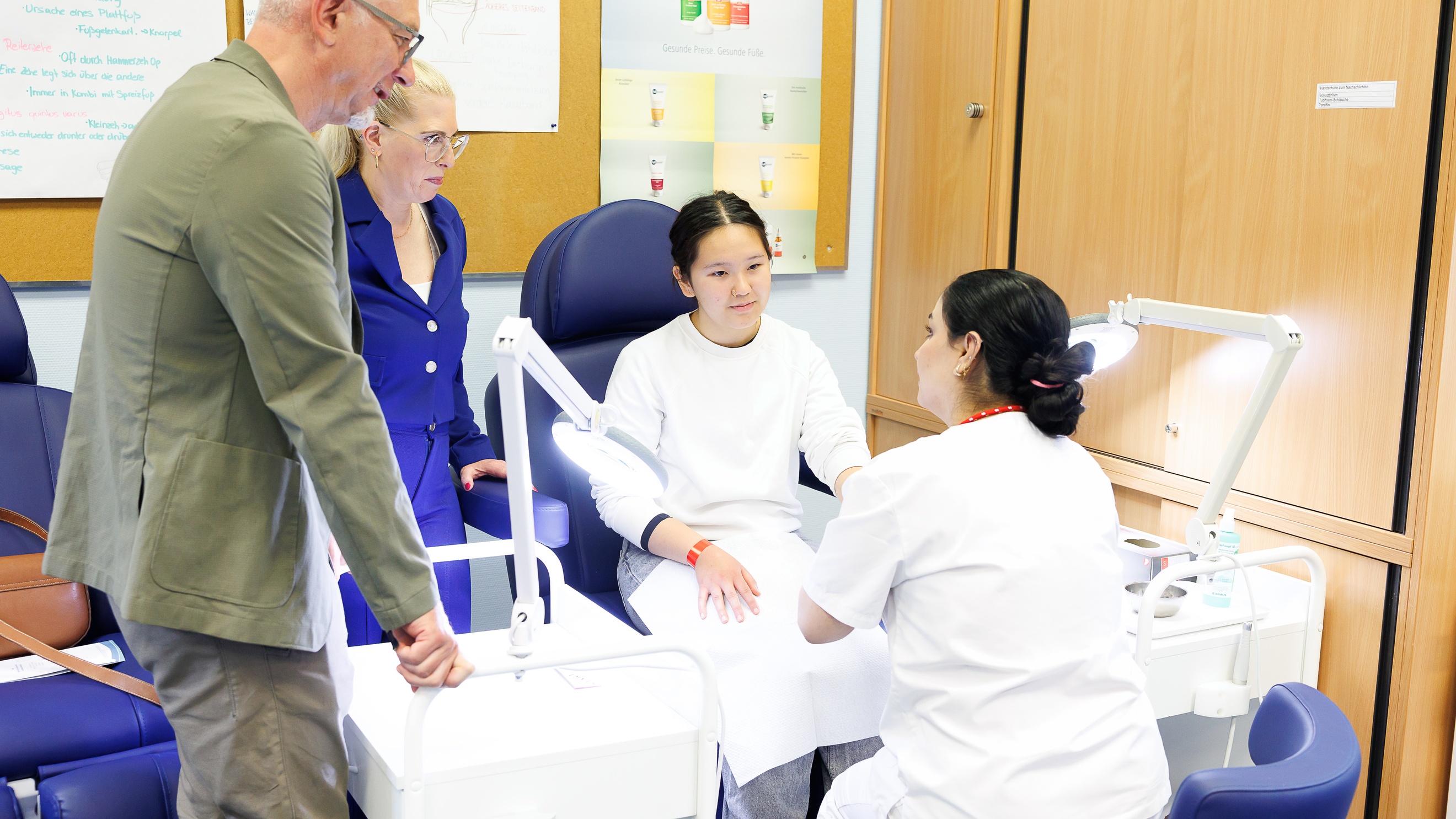 Personen stehen um einen Behandlungsstuhl mit Testperson