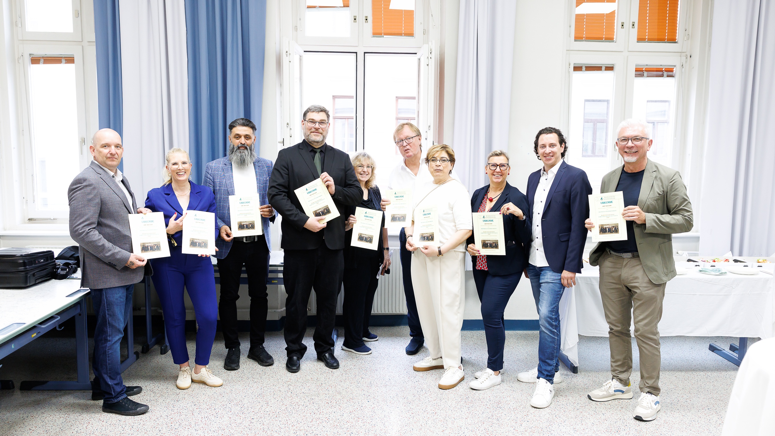 Gruppe hält Urkunden in einem Seminarraum