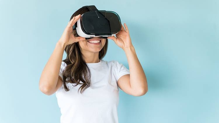Frau schaut überrascht mit VR-Brille über den Augen