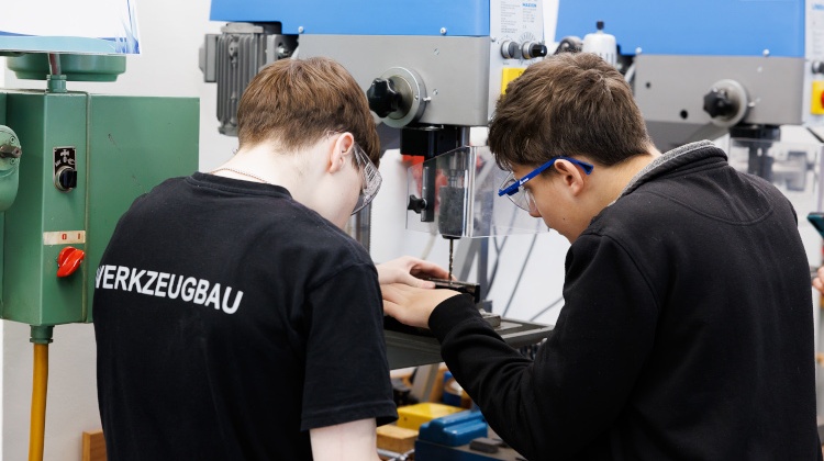 Schüler arbeiten mit Bohr-Maschine in Werkstatt