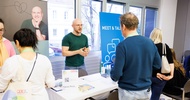 Menschen beim Kongress im Publikum und auf der Bühne