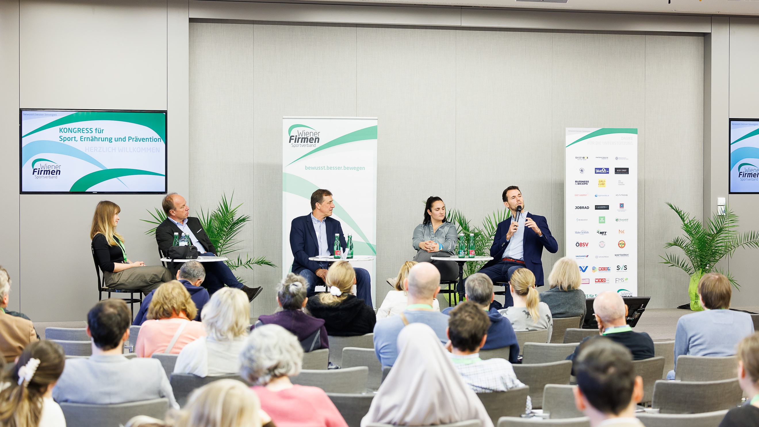 Menschen beim Kongress im Publikum und auf der Bühne