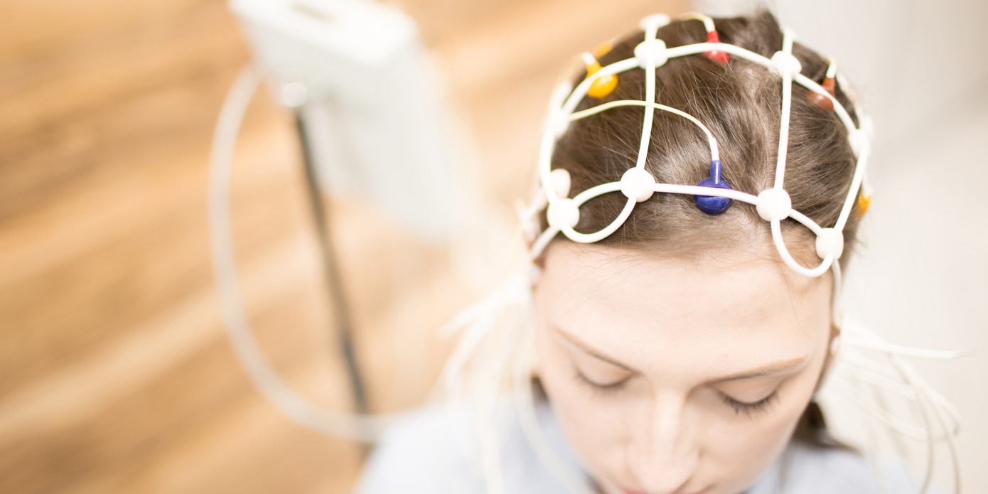 Frau trägt ein Kommunikationsgerät auf dem Kopf, welches Gehirnsignale überträgt